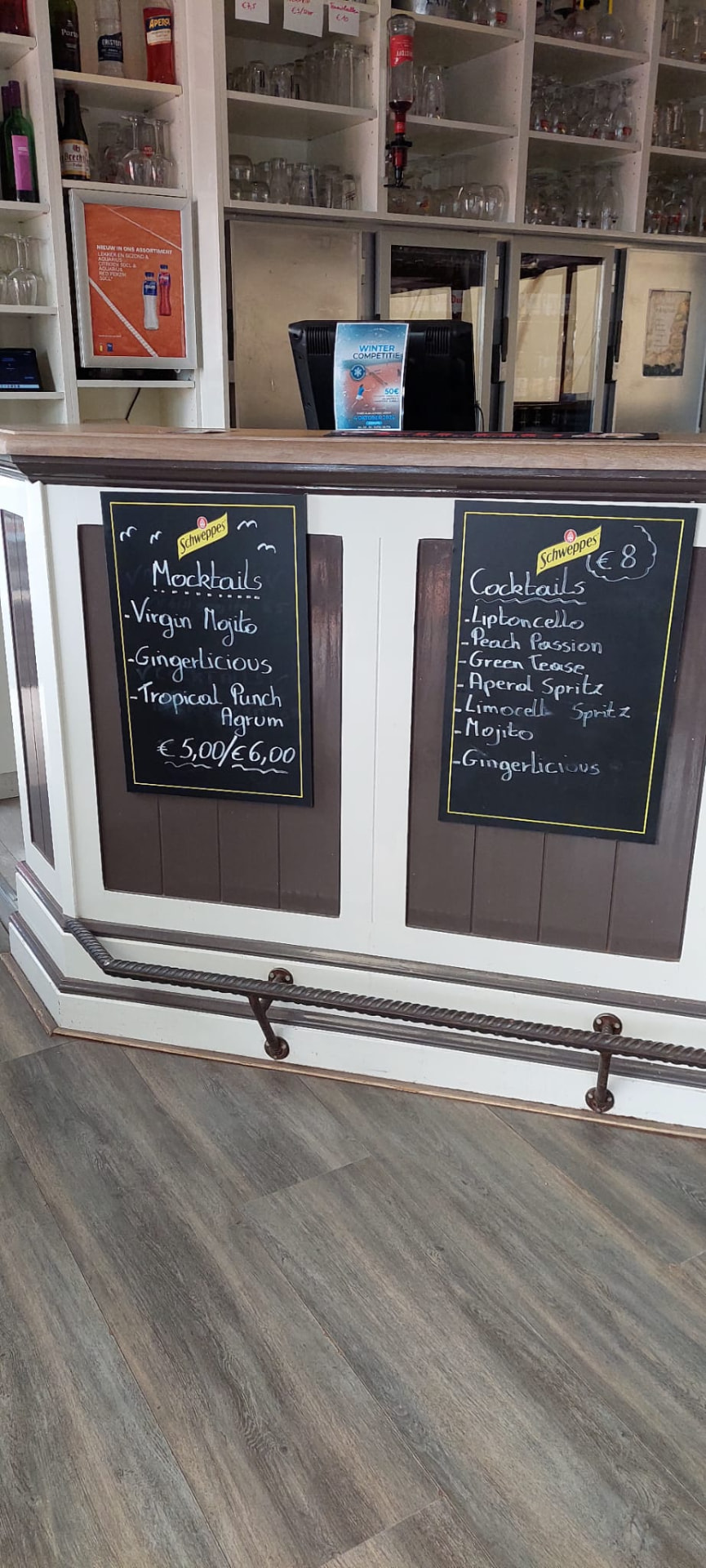 Twee krijtborden aan de toog met de suggesties voor mocktails en cocktails.